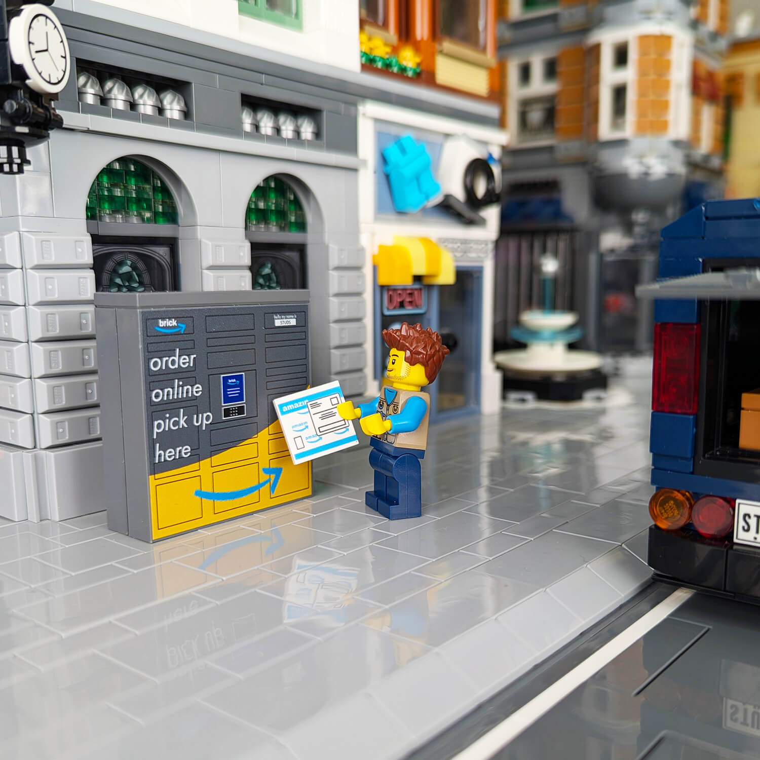 A custom-printed amazing pickup locker made using LEGO parts, featuring multiple compartments with a 'order online pick up here' text, and a blue interactive panel.